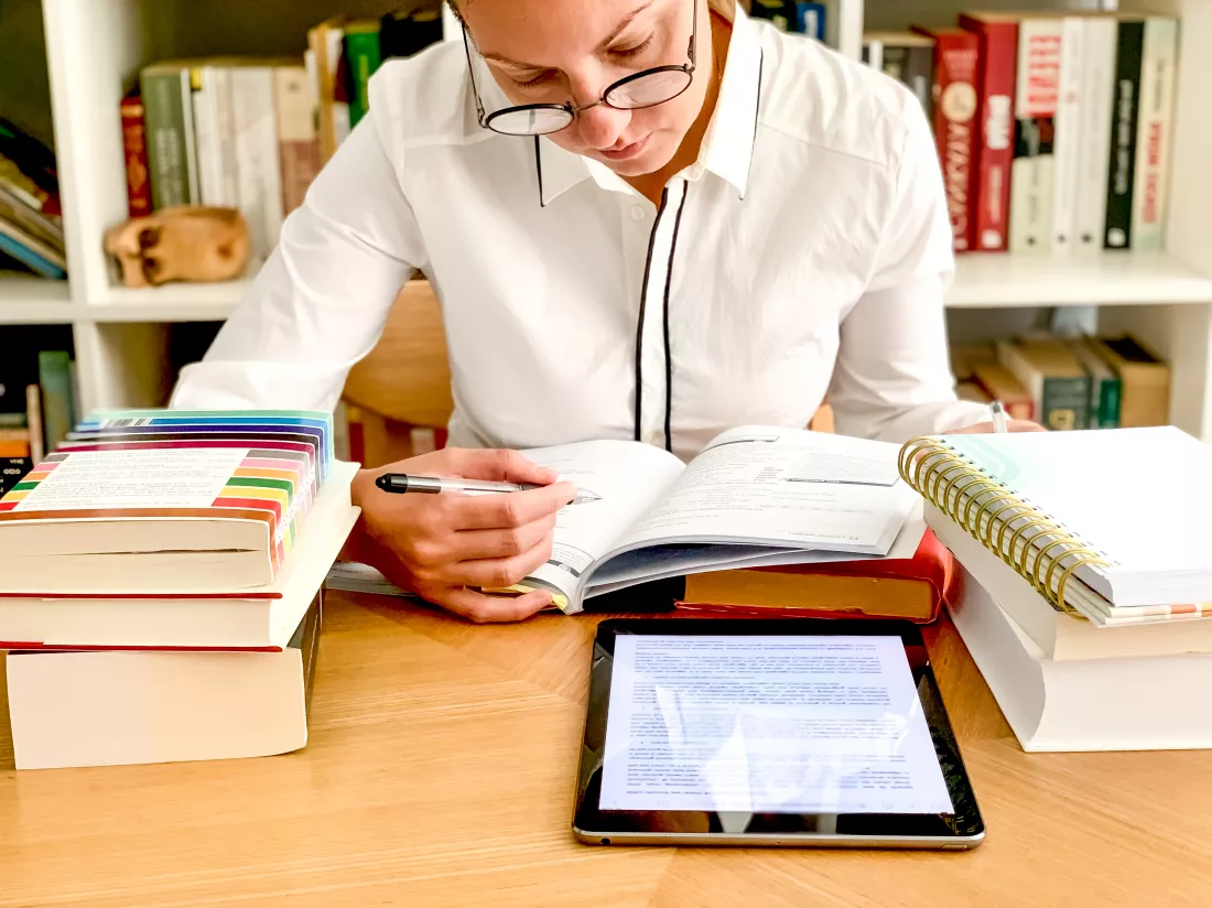 back-school-young-millennial-female-student-is-studying-from-home-pile-books-tablet-woman